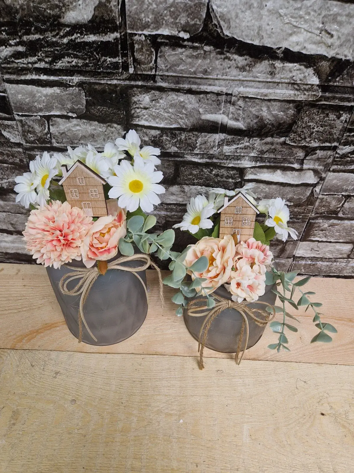 Frühlingsgesteck im Topf mit Blumen und Häuschen