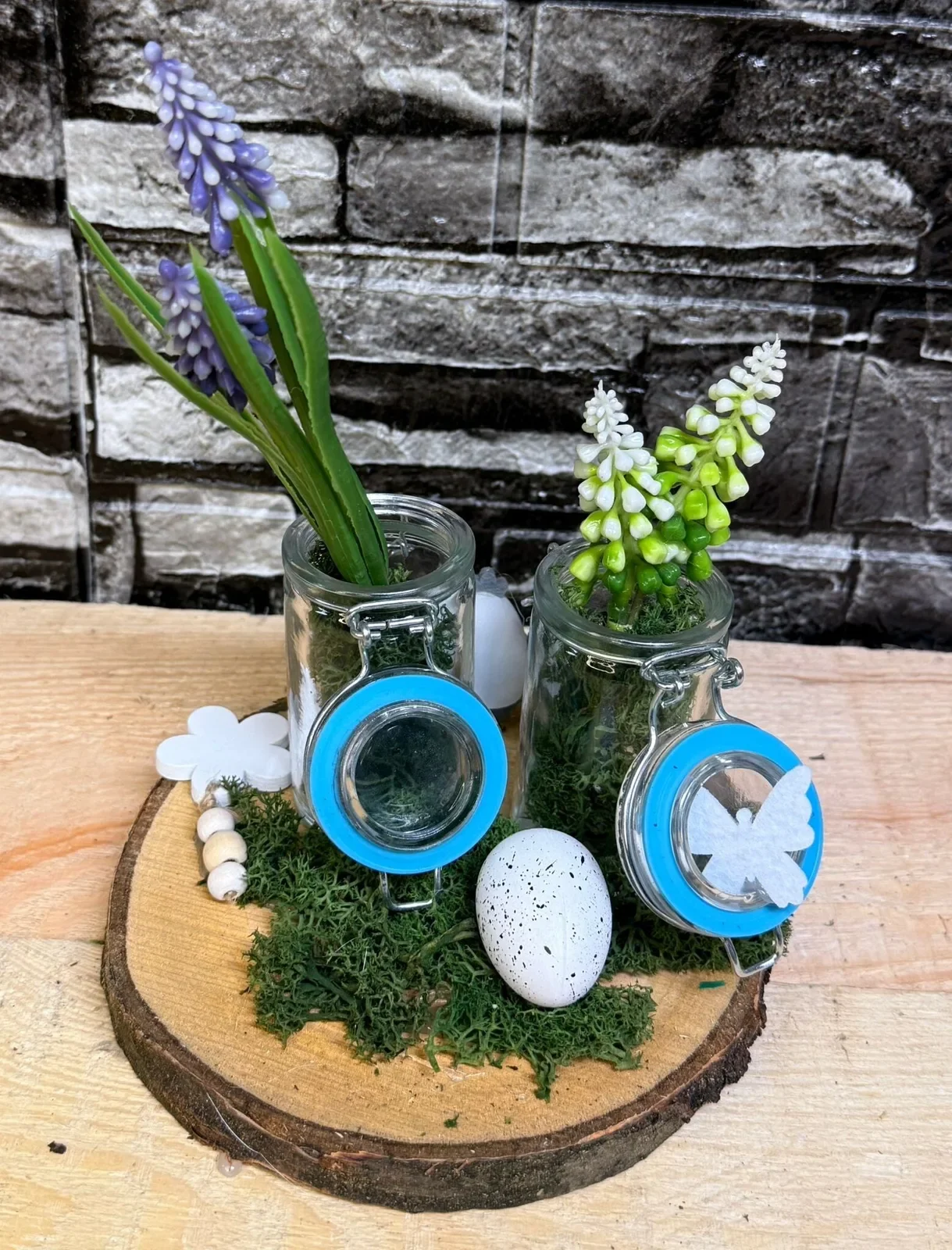 Frühlingsarrangement mit Glasgefäßen und Schmetterlingsdetail