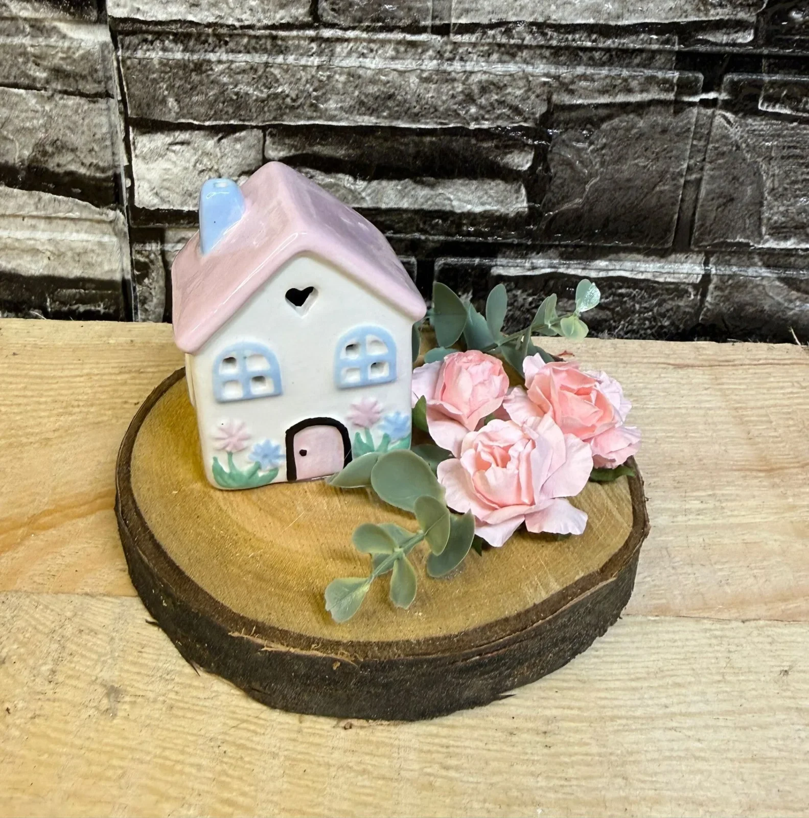 Dekoration mit Keramikhaus und Rosen