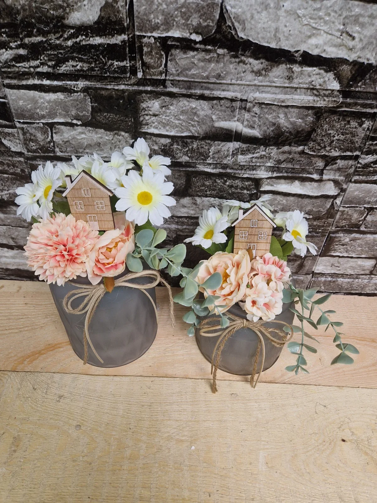 Frühlingsgesteck im Topf mit Blumen und Häuschen