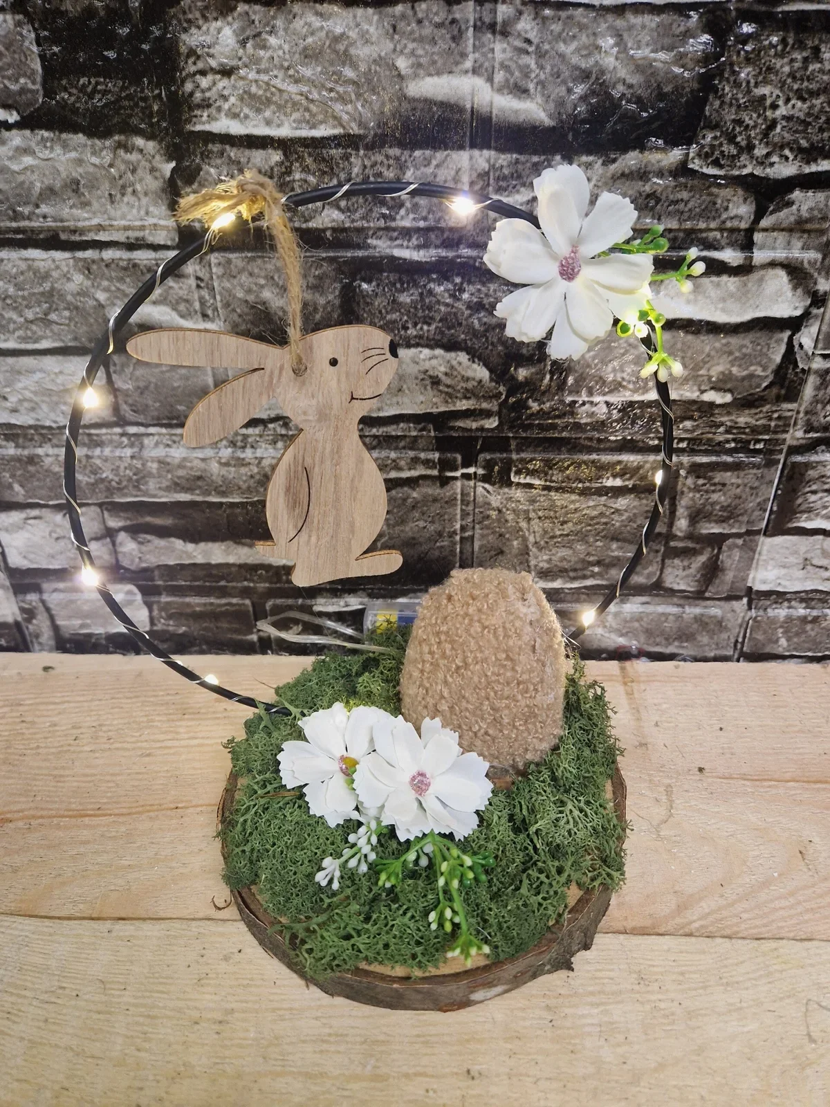 Osterdeko mit Holzhasen und Lichterring